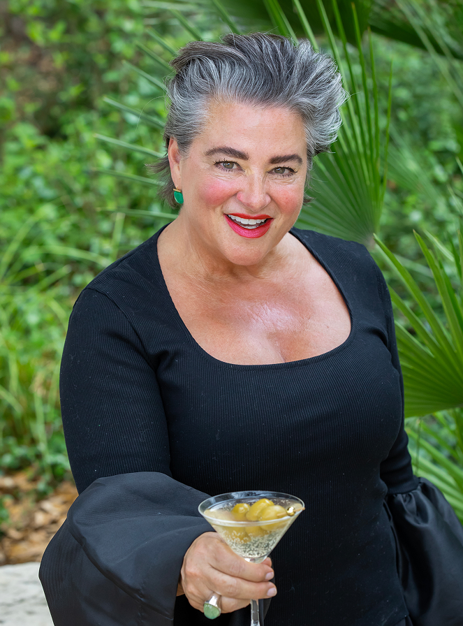 Founder Michelle Parchman smiles while holding a dirty martini with olives made using ultra premium I’m parched! vodka from Texas
